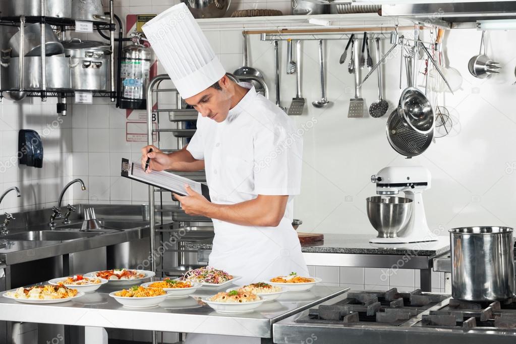 Chef With Clipboard Going Through Cooking Checklist