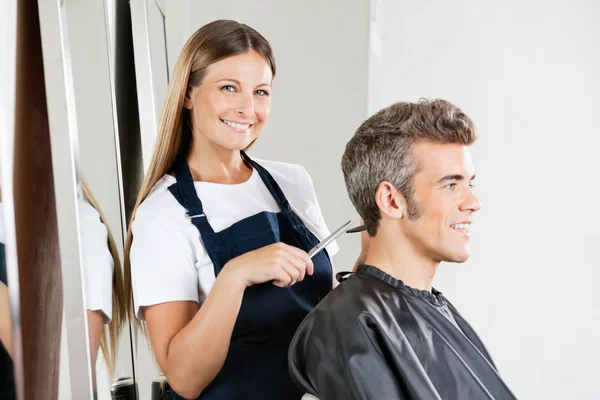 Cabeleireiro dando corte de cabelo ao cliente — Fotografia de Stock