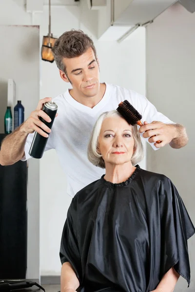 Mulher com cabeleireiro styling cabelo no salão — Fotografia de Stock