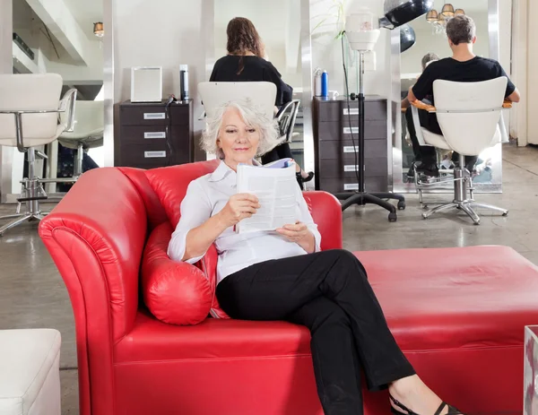 Mujer leyendo revista con clientes esperando a peluquero —  Fotos de Stock