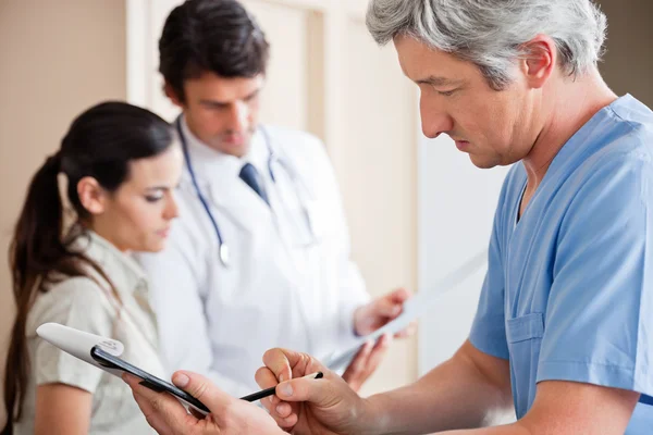 Médico escrevendo na área de transferência — Fotografia de Stock