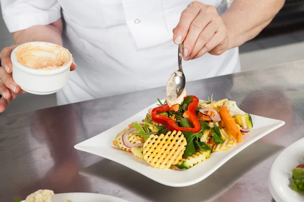 Chef hembra guarnición plato en contador — Foto de Stock