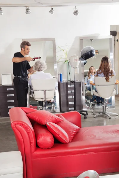 Friseur stylt Kunden die Haare im Salon — Stockfoto