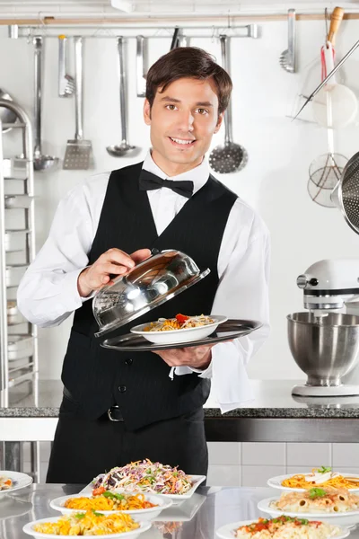 Kellner lüftet die Decke der Cloche — Stockfoto