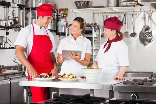 Chefs usando computador tablet no balcão da cozinha — Fotografia de Stock