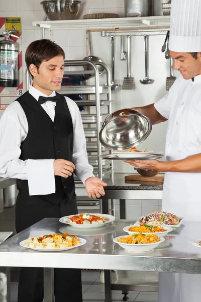Chef dando la comida del cliente al camarero — Foto de Stock
