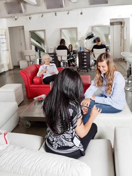 Mujer teniendo manicura con clientes esperando en el salón — Foto de Stock