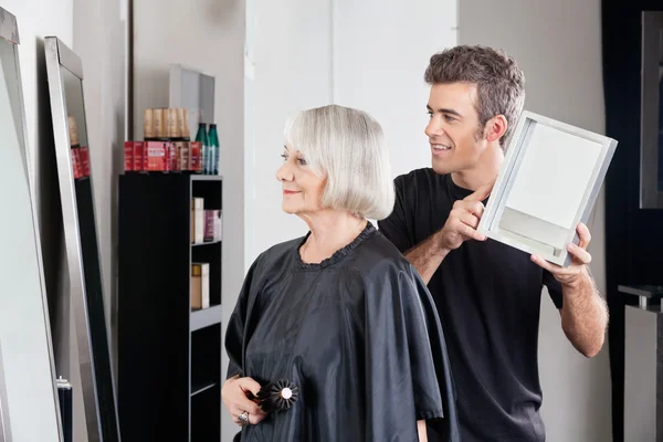 Cabeleireiro mostrando terminou corte de cabelo para mulher — Fotografia de Stock