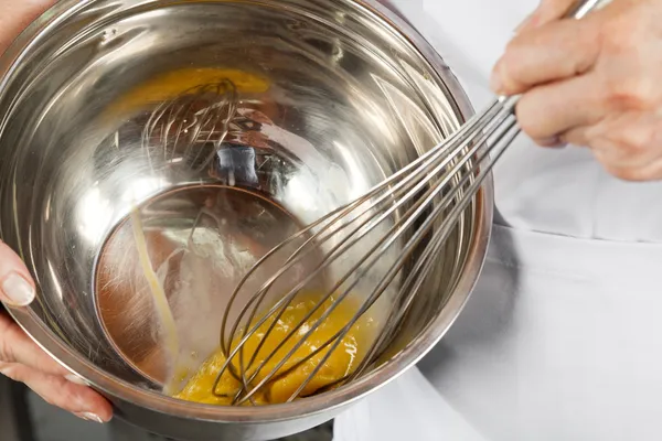 Kvinnliga kock slå ägg med wisk — Stockfoto