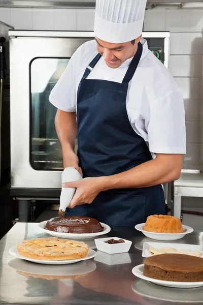 Chef decorare il cibo dolce con sacchetto tubazioni — Foto Stock