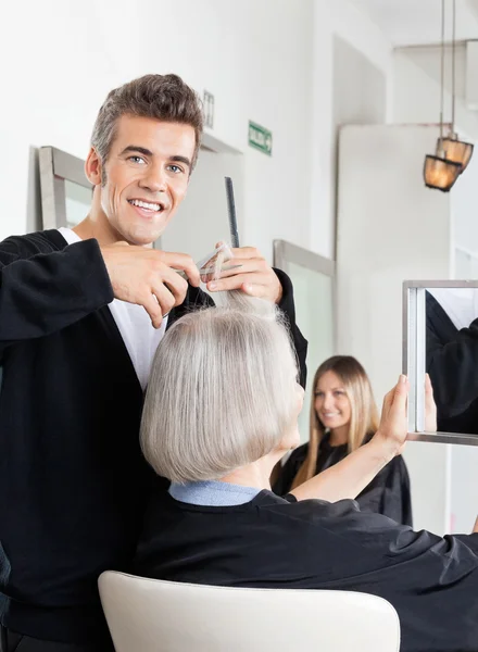 Coiffeur coupe les cheveux du client au salon — Photo