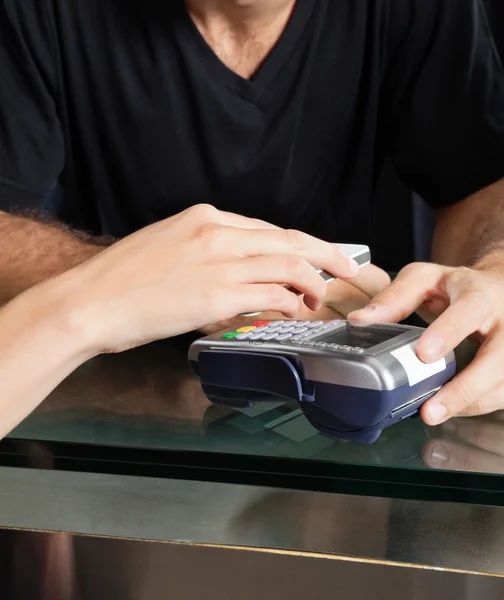 Kunde bezahlt im Salon mit Handy über elektronisches Lesegerät — Stockfoto