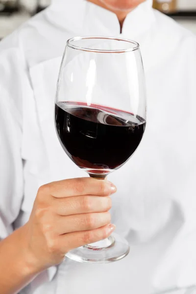 Šéfkuchař drží sklenici červeného vína — Stock fotografie