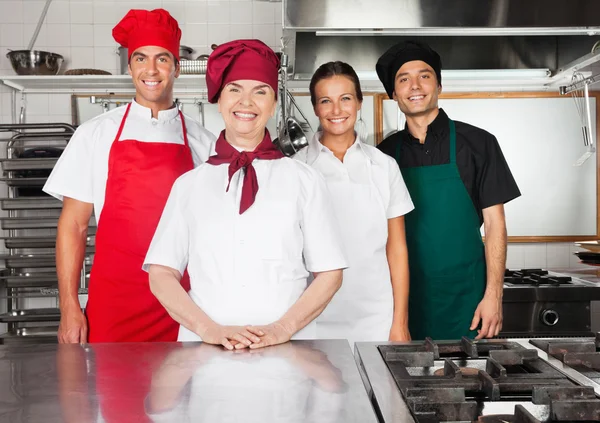 Chef felici in piedi insieme in cucina — Foto Stock