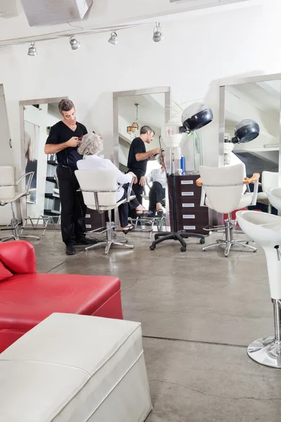 Friseur bügelt Kunden die Haare — Stockfoto