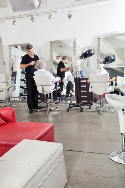 Hairstylist Ironing Customer's Hair — Stock Photo, Image