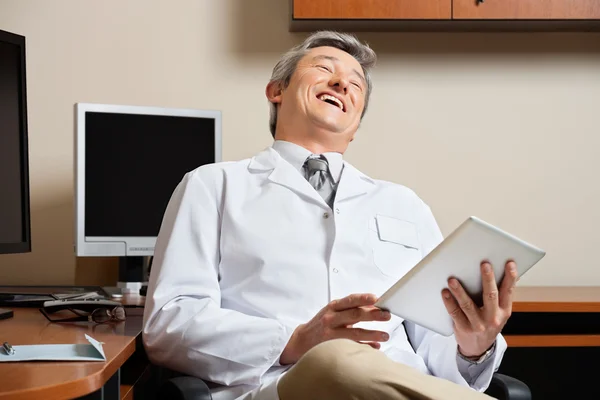 Веселый доктор держит цифровой планшет — стоковое фото