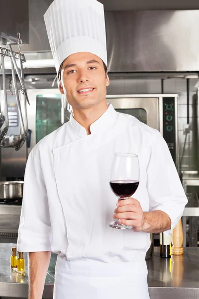 Шеф-повар держит стакан красного вина — стоковое фото