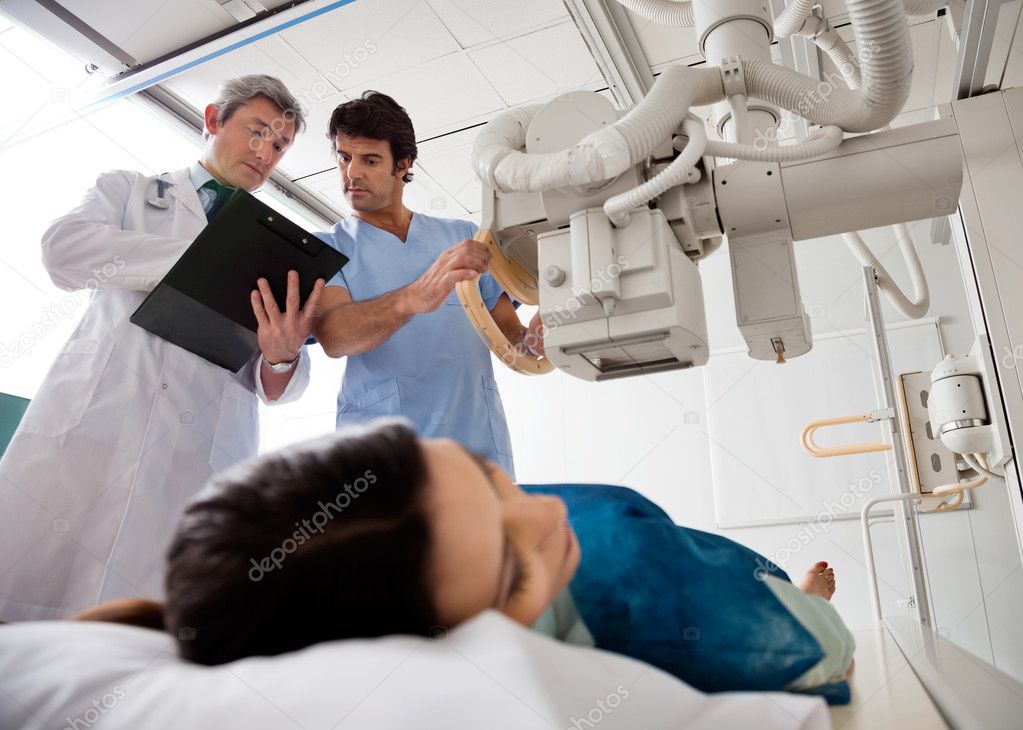 Technician Setting Up Machine To X-ray Patient