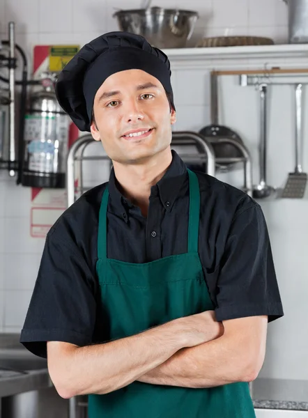 Шеф-повар со сложенными руками стоит на кухне — стоковое фото