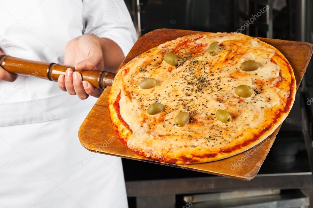 Chef Holding Pizza On Shovel