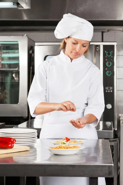 카운터에서 접시를 차압 하는 여성 요리사 — 스톡 사진