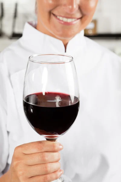Vrouwelijke chef-kok bedrijf wijn glas — Stockfoto