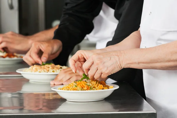 Chefs Garnishing Pasta Dishes — Stock Photo, Image