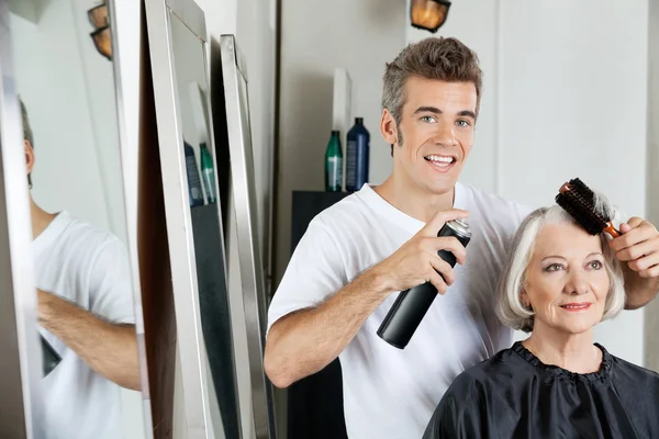 Coiffeur coiffant les cheveux du client au salon — Photo