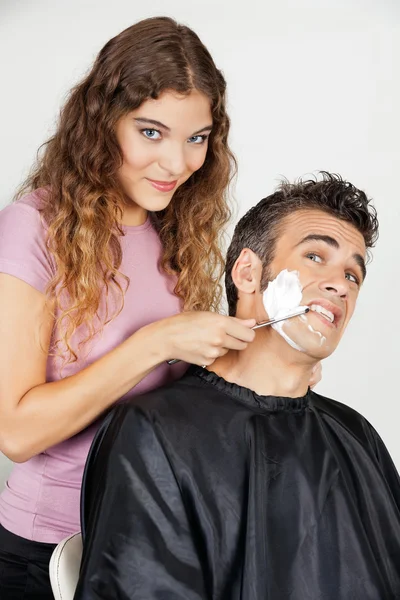 Assustado homem sendo raspado por fêmea barbeiro — Fotografia de Stock