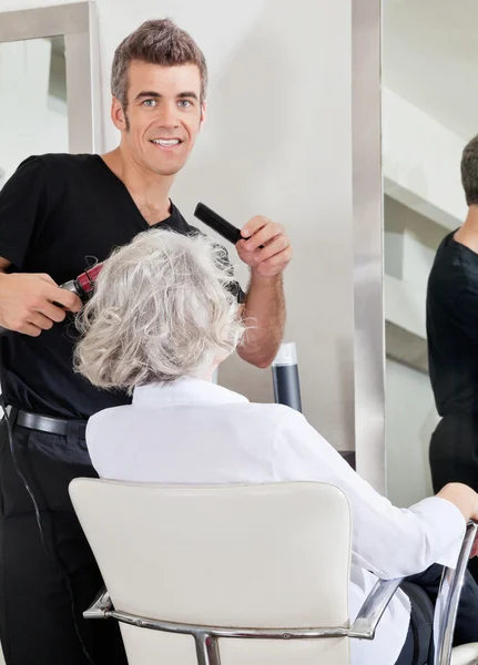 Haarstylist Curling Client van haar — Stockfoto