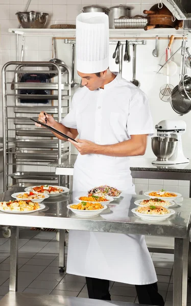 Chef con portapapeles Comprobación de platos de pasta —  Fotos de Stock