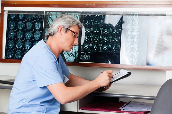 Médico escrevendo na área de transferência — Fotografia de Stock