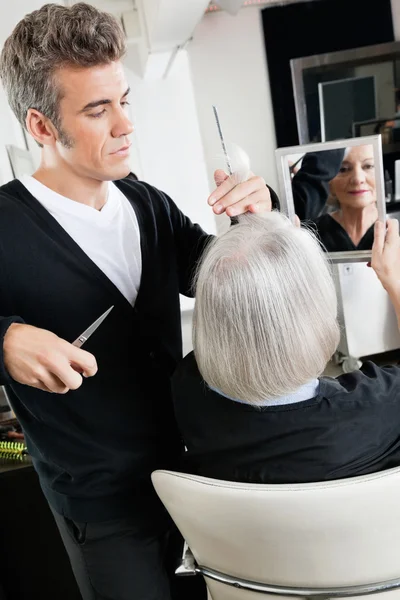 Парикмахер стрижет волосы в салоне — стоковое фото