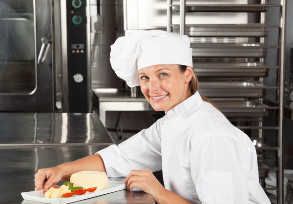 Chef femminile con piatto al bancone — Foto Stock