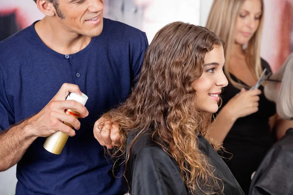 Kuaför kadının saçlarını sprey ile sabitleme — Stok fotoğraf