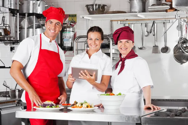 Chefs felizes usando o computador Tablet na cozinha — Fotografia de Stock