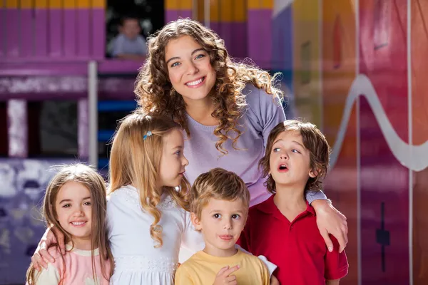 Felice insegnante con carino bambini in scuola materna — Foto Stock