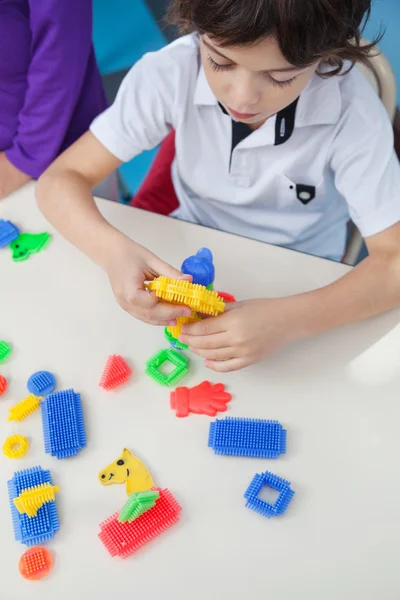 Boy Playing With Blocks At Desk In Kindergarten — Stock Photo, Image