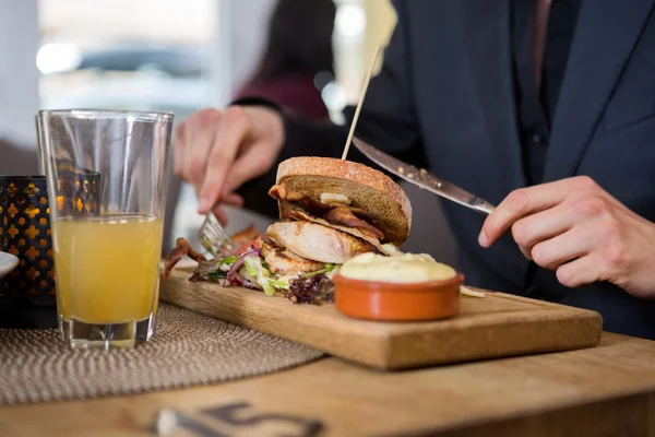 Jonge zakenman gelet sandwich in café — Stockfoto