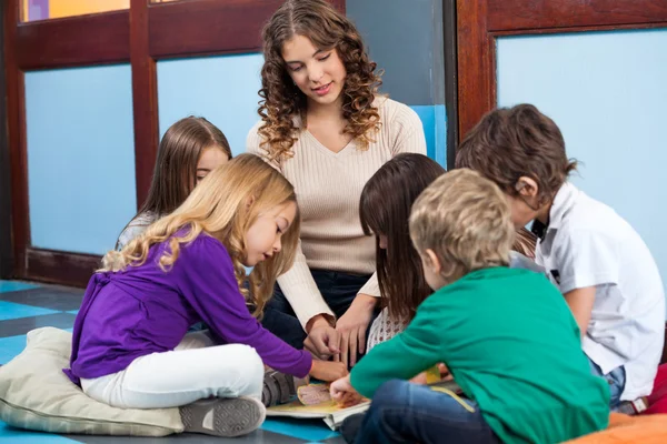 Teacher reading book to preschool students Stock Photo by ©michaeljung
