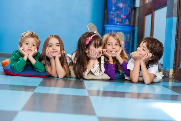 Children Lying In A Row On Floor — Stock Photo, Image