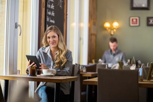 Kobieta w ciąży z cyfrowego tabletu w tabeli — Zdjęcie stockowe