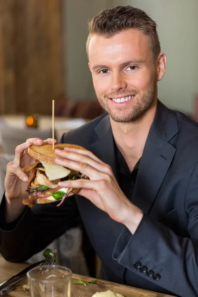 Επιχειρηματίας εκμετάλλευση σάντουιτς στο εστιατόριο — Φωτογραφία Αρχείου
