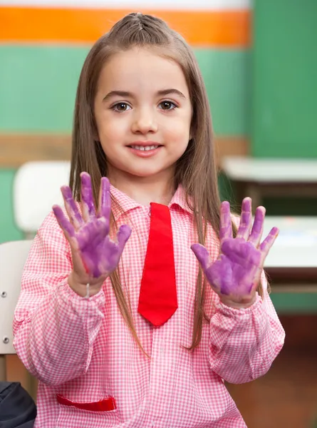 Mädchen zeigt farbige Hände im Klassenzimmer — Stockfoto