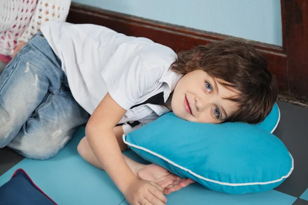 Мальчик, лежащий на подушке в форме сердца — стоковое фото