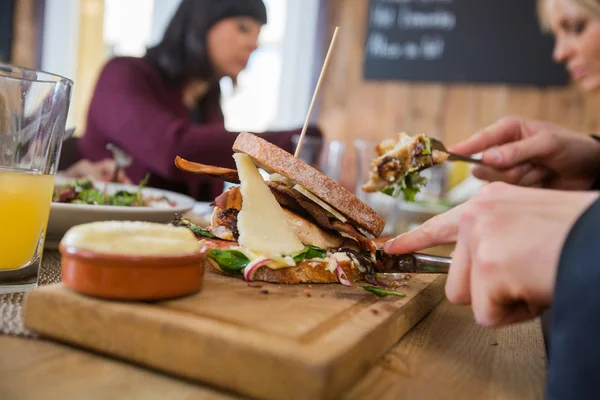 Zakenman met hamburger met collega 's — Stockfoto