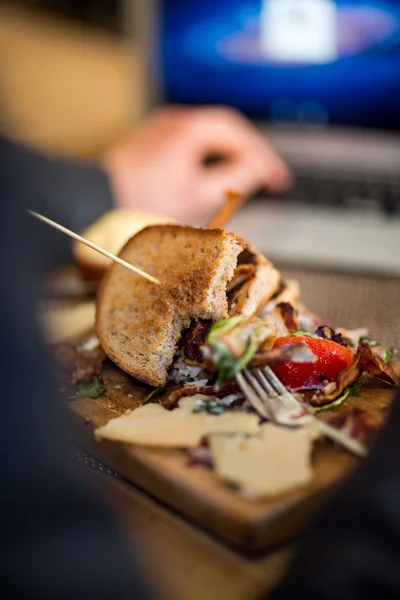 Half opgegeten sandwich op houten plaat — Stockfoto