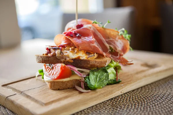 Välsmakande parma skinka sandwich på träplatta — Stockfoto