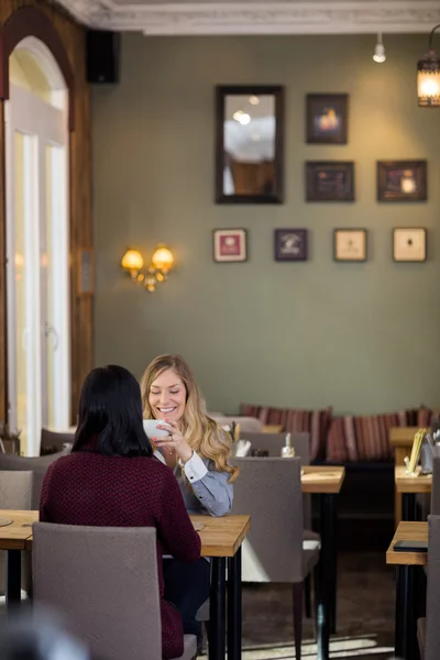 Mujer joven feliz tomando café con un amigo — Foto de Stock